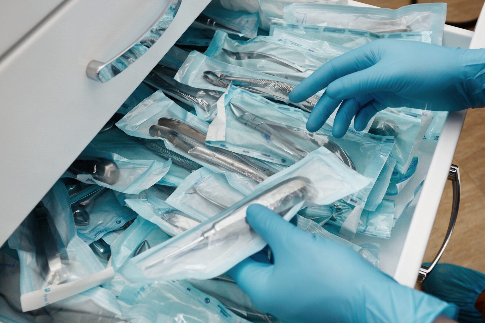 medical laboratory technician holding a set of sterile disposable instruments medical laboratory technician holding a set of sterile disposable instruments